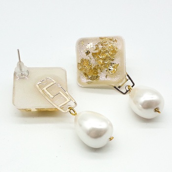 Boucles d’oreilles en résine motif carré couleur beige et dorée avec une perle de culture fait main par Créanna Bijoux حلق بالرزين لون الدهبي مع جوهرة بيضاء صناعة حرفية يدوية